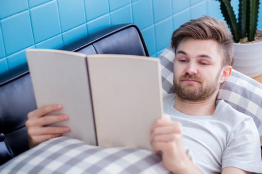 relax man reading a book lying on sofa education concept.