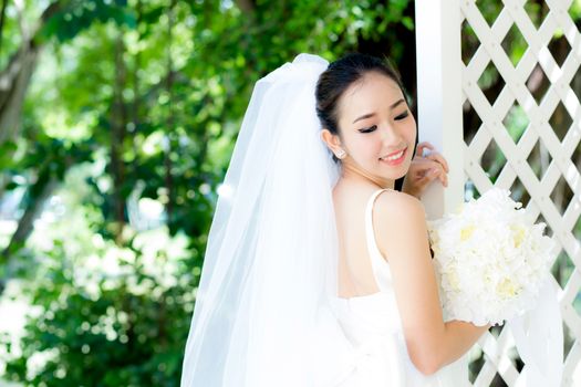 beautiful young woman on wedding day in white dress in the garden. Female portrait in the park - Selective focus.