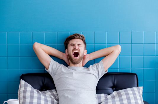 man yawning and going asleep in his  living room