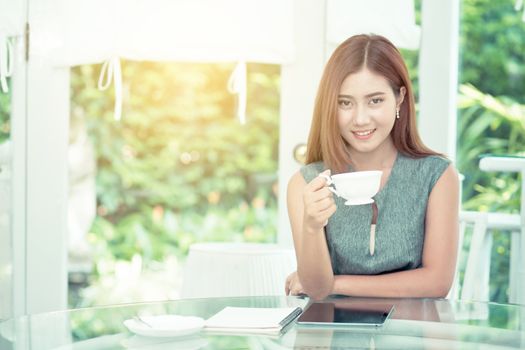 Beautiful businesswoman have enjoyed in the garden with coffee.