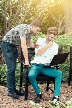 Two business people use of the notebook computer at outdoor.