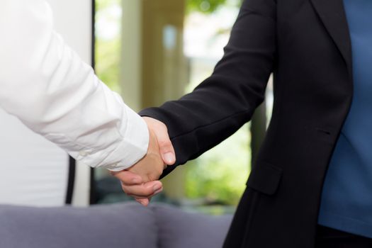 Handshake of businessman and businesswoman after successful business meeting.