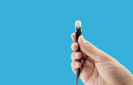 A LAN connector in hand isolated on blue background - clipping part.