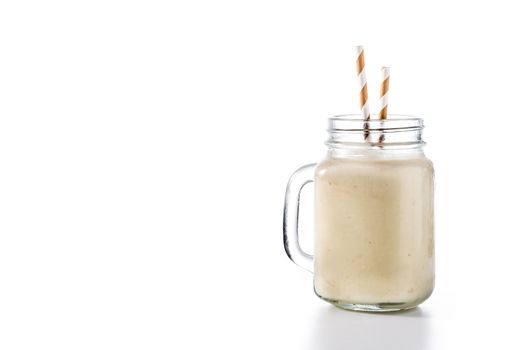 Banana smoothie with almond in jar isolated on white background