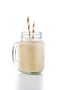 Banana smoothie with almond in jar isolated on white background