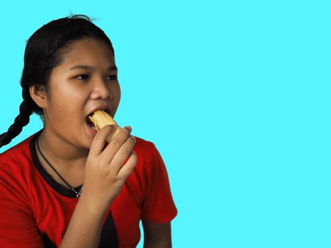 The girl eats hot dog Happily Isolated on a yellow background. Embed clipping path. Junk food concept