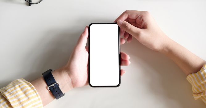 Top view Woman sitting and holding blank screen mock up mobile phone.