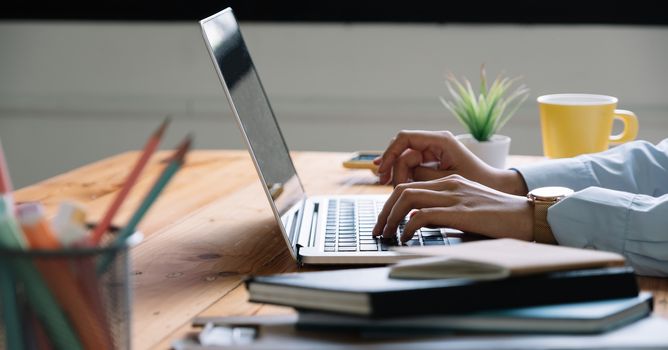 Close up Woman working at home office hand on laptop keyboard.