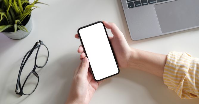 Top view Woman sitting and holding blank screen mock up mobile phone.