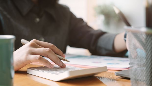 Woman use calculator for finance and accounting Analyze financial budget.