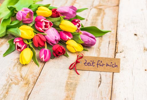 Colorful bunch of flowers and tag with german text, Zeit fuer mich, means resting