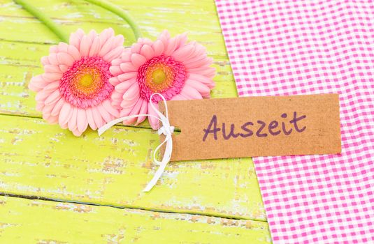 Pink flowers gift and label with german word, Auszeit, means timeout