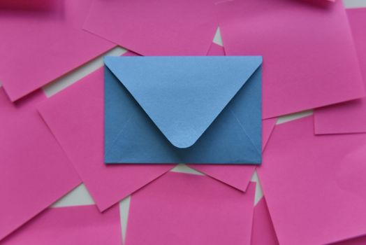 selective focus, single blue envelope in the middle of pink stickers