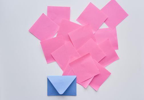 selective focus, pink paper stickers in chaos and blue envelope down on the white background