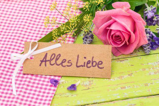 Romantic bouquet of pink rose flower and card with german text, Alles Liebe, means love