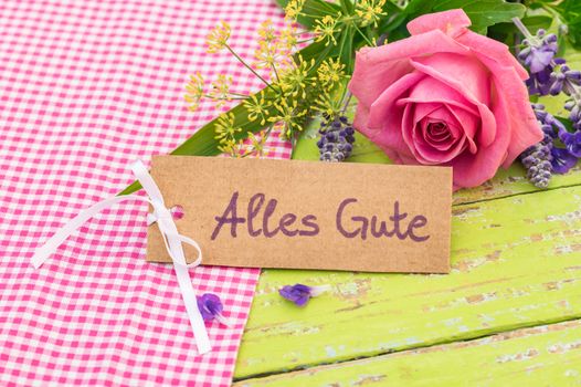 Bouquet of rose flower and card with german text, Alles Gute, means best wishes
