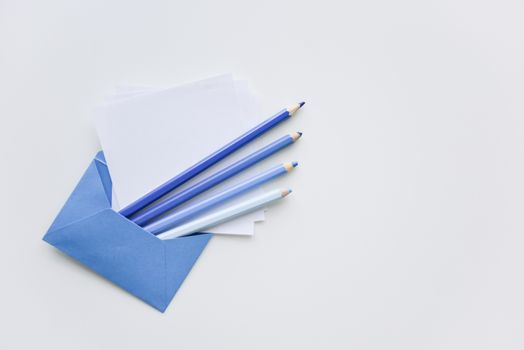 fselective focus, our blue pencils and white papers out of the blue envelope with copy space on top