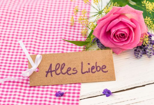 Bunch of pink rose flower and card with german text, Alles Liebe, means love