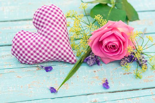 Lilac heart with romantic rose flower on blue wooden background