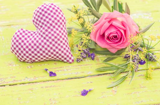 Purple heart and bunch of flowers with rose on wooden background