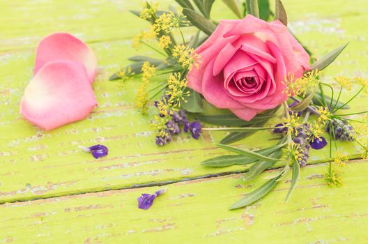 Bouquet of flowers with pink rose on wooden table background