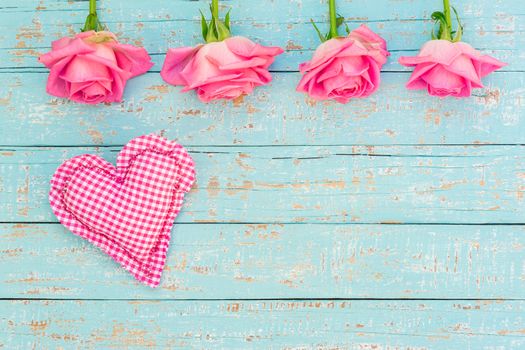 Pink heart and roses on light blue wood background for Valentine's day with copy space
