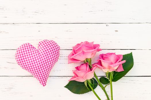 Pink heart with bunch of roses on white wood with copy space 