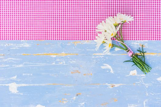 Beautiful bouquet of daisy chamomile flowers on blue wooden table background with copy space