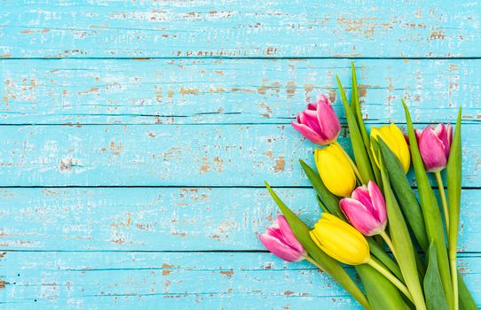 Bouquet of tulips on turquoise wooden background with copy space