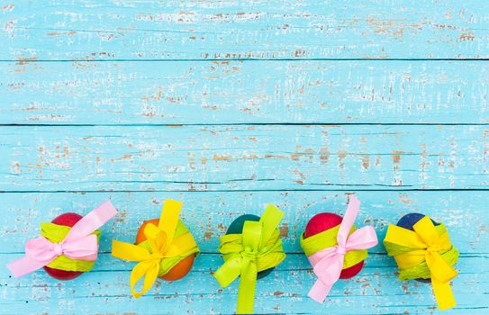 Colorful easter eggs decoration on turquoise wooden background with copy space
