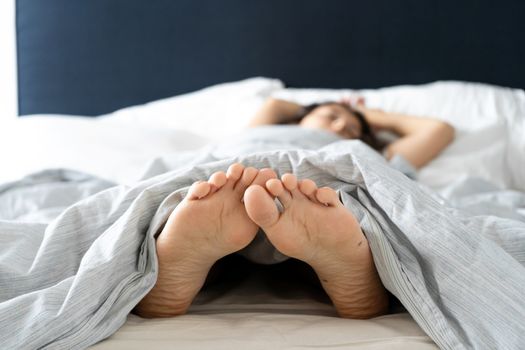 Feet of a sleeping girl in bed in the morning. Spy photo