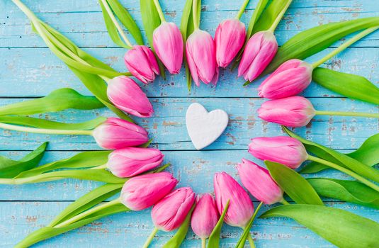 Romantic love heart with pink flowers on blue wooden background