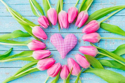 Pink heart and tulip flowers on blue wood background for Mother's day