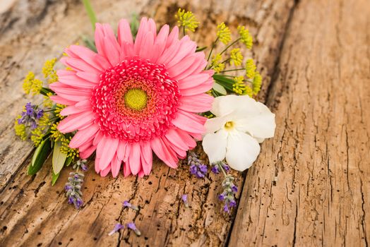 Romantic bouquet of flowers with pink gerbera daisy on wooden background