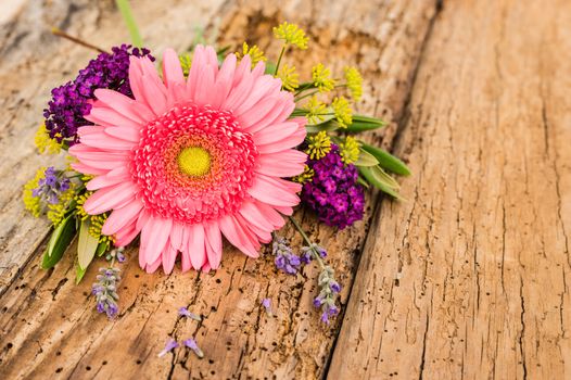 Beautiful bouquet of pink gerbera daisy flowers on old wooden background with copy space