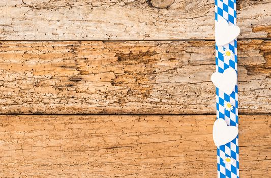 Rustic old wooden planks with bavarian border, hearts, flowers and copy space