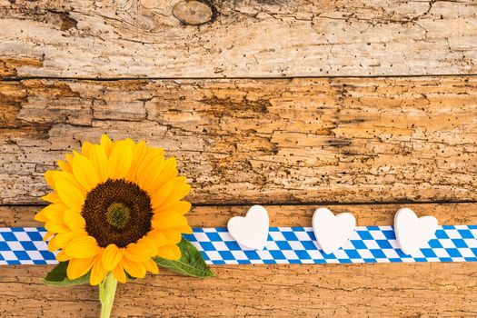 Old wooden planks background with autumn flower and hearts for bavarian Oktoberfest