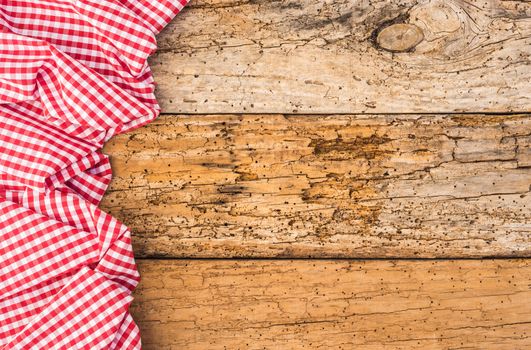 Tablecloth on wooden table, food background, red checked fabric, top view, copy space