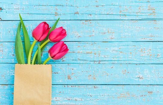 Beautiful red tulip spring flowers arrangement on blue wooden background