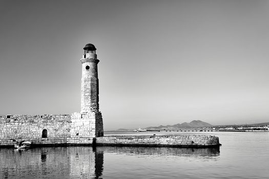 stone wall and historic lighthouse in the port of Rethymnon on the island of Crete, black and white