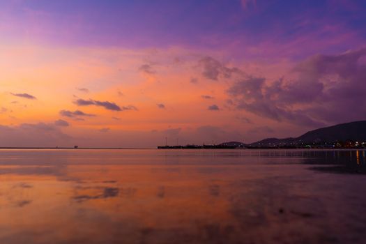 Burning bright sky during sunset on a tropical beach. Sunset during the exodus, the strength of people walking on water.