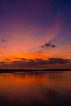 Burning bright sky during sunset on a tropical beach. Sunset during the exodus, the strength of people walking on water.