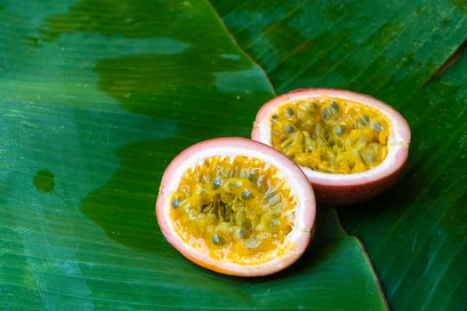 Ripe passion fruit, on a wet banana leaf. Vitamins, fruits, healthy foods.