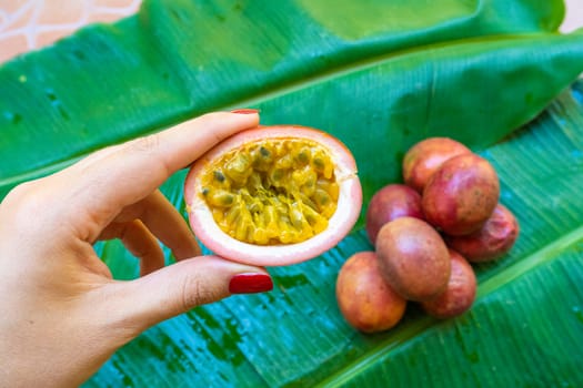 Ripe passion fruit, on a wet banana leaf. Vitamins, fruits, healthy foods.