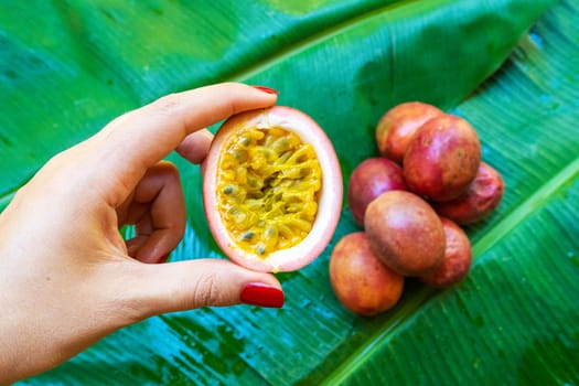 Ripe passion fruit, on a wet banana leaf. Vitamins, fruits, healthy foods.