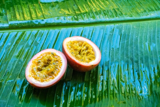 Ripe passion fruit, on a wet banana leaf. Vitamins, fruits, healthy foods.