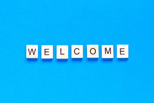 welcome sign in wooden letters on a blue background. Business concept, sales, stores, gifts. The view from the top. top view