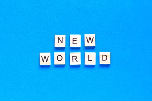 NEW WORLD word on wooden alphabet cube. New normal concept. flat layout. top view