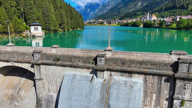 Alpin lake and dam in summertime, view from drone, Auronzo, italian dolomites.