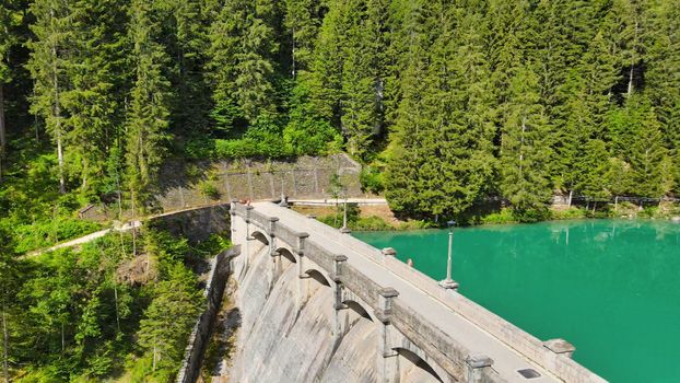 Alpin lake and dam in summertime, view from drone, Auronzo, italian dolomites.